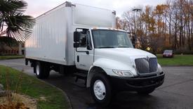 A white 2017 International 4300 box truck with a large cargo area and orange clearance lights on the roof