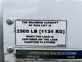 A sign indicating the maximum capacity of a lift on a 2018 Isuzu NRR, stating 2500 lb 1134 kg when the load is centered on the load carrying platform