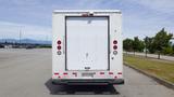 A 2011 Ford Econoline truck viewed from the rear with a white cargo box and red taillights