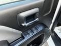 Close-up of the door panel of a 2017 GMC Sierra 1500 featuring a chrome door handle and power window controls