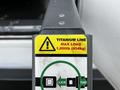 A 2016 Ford Econoline with a warning label on the side indicating a maximum load of 1000 pounds and featuring a titanium line