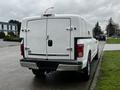 A 2017 Ford F-150 with a white truck bed cover parked on the side of a street