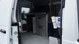 A 2012 Ford Transit van interior featuring a metal storage unit with two drawers and a flat metal top