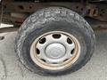 Close-up of a rugged tire mounted on a 2010 Ford F-150 showing a silver wheel rim and heavy treads designed for off-road traction