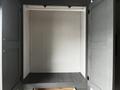 A 2022 Aspen Trail cabinet with two open doors revealing an empty interior space and a shelf at the bottom