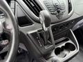 Interior shot of a 2017 Ford Transit showing the gear shift lever with P R N D M positions and various control buttons and cup holders