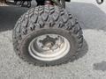 Close-up of a rugged tire from a 2012 Toro Groundsmaster 5910 featuring deep treads and a metallic wheel rim