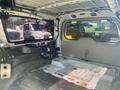 A 2013 Ford Expedition with the interior stripped down showing the bare metal structure and flooring without seats or upholstery