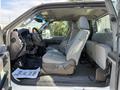 The interior of a 2012 Ford F-350 SD featuring gray fabric seats and a driver's area with a steering wheel and dashboard