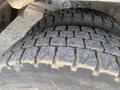 Close-up of a heavily worn tire from a 2002 Ford F-550 showing deep tread patterns and signs of significant use