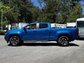 A blue 2021 Chevrolet Colorado pickup truck with a crew cab and chrome accents parked at an angle