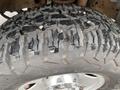 Close-up of a rugged tire tread on a 2005 Ford F-350 SD showing deep grooves and an aggressive pattern designed for off-road performance