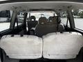 Interior view of a 2003 Mitsubishi 7 Passenger Van showing two rear seats with a spacious layout and seat belts visible