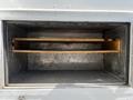 Interior view of a storage compartment in a 2009 Morgan Olson Workhorse with two wooden shelves set against metallic walls