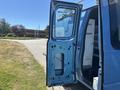 A blue 2008 Ford E-350 van with an open passenger door showing the interior metal frame and storage compartments inside the van