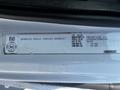 A white 2004 Freightliner M2 truck with a label displaying vehicle information including model type and identification numbers