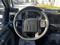 Steering wheel of a 2011 Ford F-350 SD with the Ford logo visible and dashboard gauges in the background