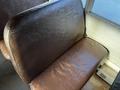 Brown, worn bus seat inside a 2005 Blue Bird 48 Passenger Bus with textured upholstery