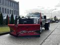 A 2012 Ford F-550 equipped with a large red snow plow attached to the front