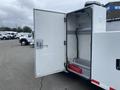 A 2003 Ford F-450 SD with an open side compartment revealing a clean interior space and a red toolbox at the bottom