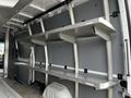 Interior view of a 2016 Mercedes-Benz Sprinter showing metal shelving units attached to the walls for storage purposes