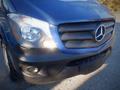 Front view of a blue 2017 Mercedes-Benz Sprinter highlighting the grille and headlights with the iconic Mercedes logo prominently displayed