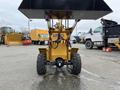 A yellow 2024 AGT Industrial KRW23 Mini Loader with a front bucket and large wheels positioned facing forward