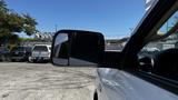 A 2019 RAM 3500 with its side mirror visible reflecting another vehicle