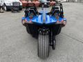 A blue 2020 Polaris Slingshot with three wheels and a sleek design featuring two seats and distinctive rear lights