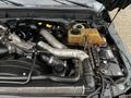 Engine bay of a 2012 Ford F-550 with various components including pipes cables and a reservoir tank