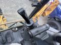 A close-up of the control levers inside a 2011 John Deere 310SJ 4x4 Wheel Loader with an extended hoe and a 4 in 1 bucket