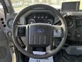 A 2011 Ford F-450 SD steering wheel with controls and dashboard displays showing various gauges and a small screen mounted above the dashboard