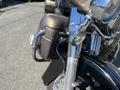 Close-up of a 2004 Harley-Davidson Flhtcui motorcycle showing the front wheel fork headlights and chrome details