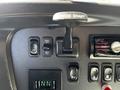 The interior dashboard of a 2012 Freightliner M2 112 featuring various control buttons including trailer brake and speed control.