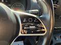 Close-up of the multifunction steering wheel control in a 2023 Mercedes-Benz Sprinter featuring volume buttons and various command controls