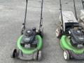 Three Honda Lawnboy mowers and two Stihl line trimmers lined up in a row showing their handles and engine compartments