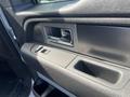Interior door panel of a 2014 Ford F-150 featuring a handle, window control buttons, and storage compartment
