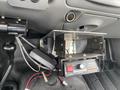 Close-up of a metal bracket with a control panel and wiring for a 2003 Ford F-450 SD located inside the vehicle's cabin