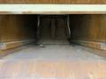 Interior view of a 2010 Autocar Xpeditor showing a dirty empty cargo space with worn metal surfaces and debris present on the floor
