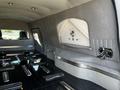 The interior of a 2013 Lincoln MKT limousine features gray upholstery with decorative stitching and chrome accents along the sleek black flooring and seating area.
