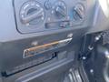 Dashboard controls of a 2018 Kubota RTV-X 1100 C featuring knobs for air conditioning and climate settings along with a warning label and storage compartment