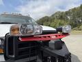 A 2007 Ford F-450 truck with a red snow plow attachment on the front and two large headlights visible on either side of the plow