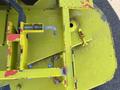 A close-up of a yellow Kubota F3990 mower deck showing metal parts including levers and mounts with some signs of wear and red paint chips