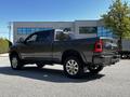 A 2022 RAM 3500 pickup truck in a dark gray color with chrome accents and large wheels is parked at an angle showcasing its robust design and sporty styling