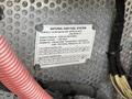 A metal plate labeled "NATURAL GAS FUEL SYSTEM" with specifications including system pressure and installation information on a bus exterior