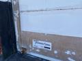 A close-up view of a faded white delivery truck with visible wear on the surface featuring a prominently displayed Transglobal logo and serial number label