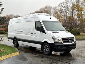 A white 2016 Mercedes-Benz Sprinter van parked at an angle with a high roof and black accents on the side and wheels