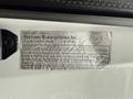 A metallic label affixed to the interior of a 2008 Ford F-350 providing manufacturing details and compliance information