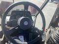 Close-up of the steering wheel and dashboard of a 2010 Trackless MT6 featuring various gauges and controls