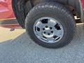 A close-up view of a chrome wheel on a 2011 Chevrolet Avalanche showing tire tread and bolt pattern